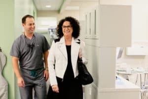 Woman and dentist walking next to each other in dental office