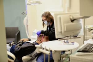 A female dental assistant prepping a patient for dental work through the use of sedation dentistry at Walton Dental Group.
